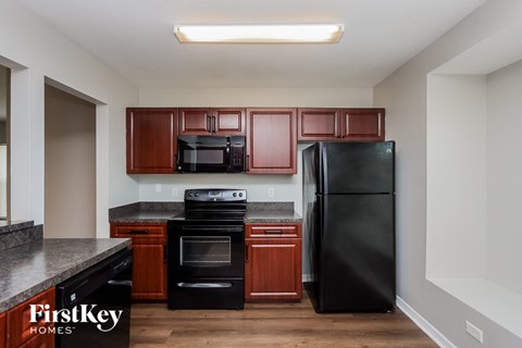 a kitchen with black appliances and wooden cabinets