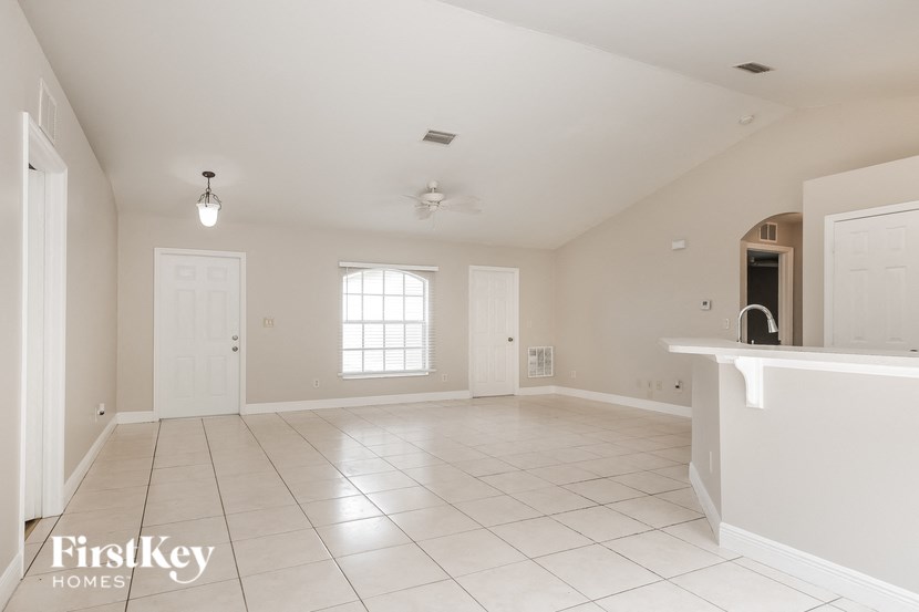 an empty living room and kitchen with a sink and a counter