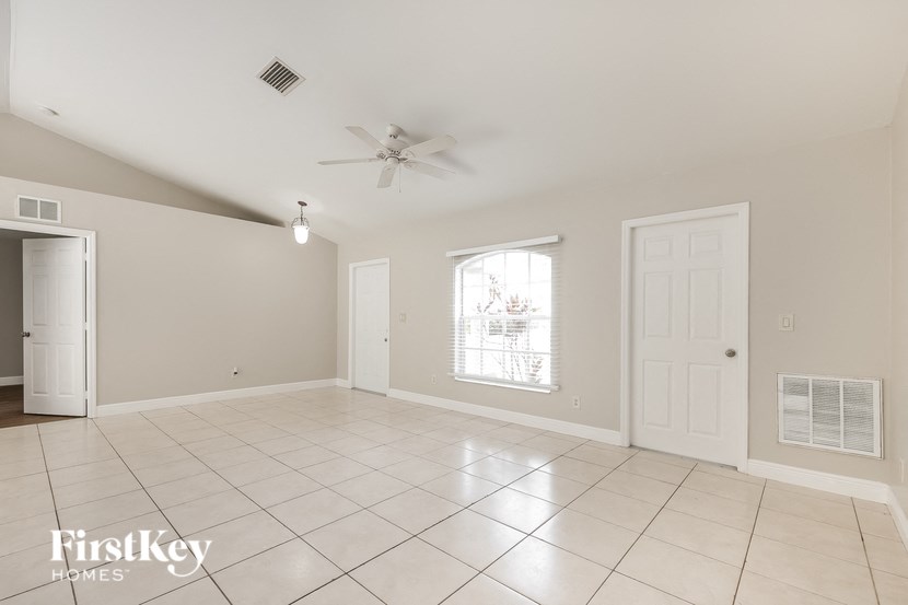 an empty living room with a ceiling fan
