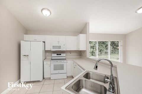 a white kitchen with white appliances and a sink