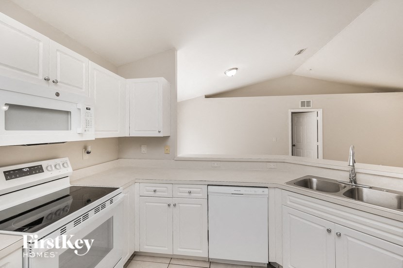 a kitchen with white cabinets and a stove and a sink
