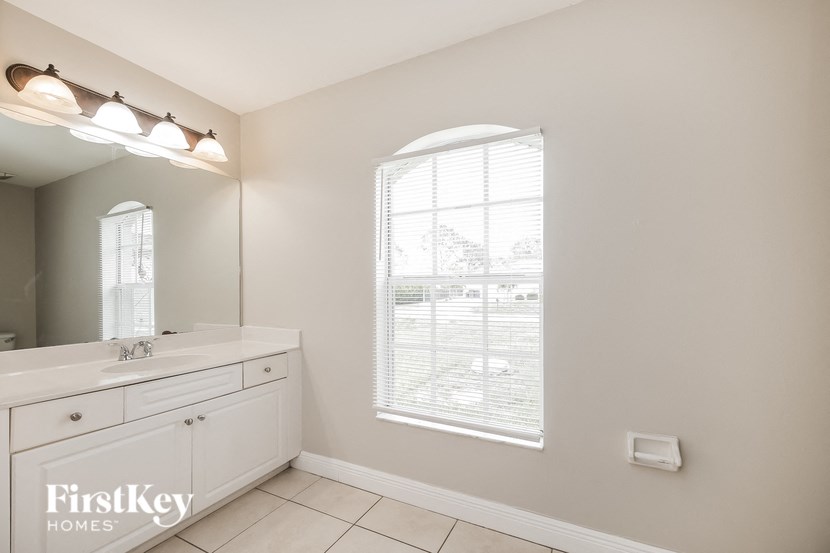 a bathroom with a large window and a sink and a mirror