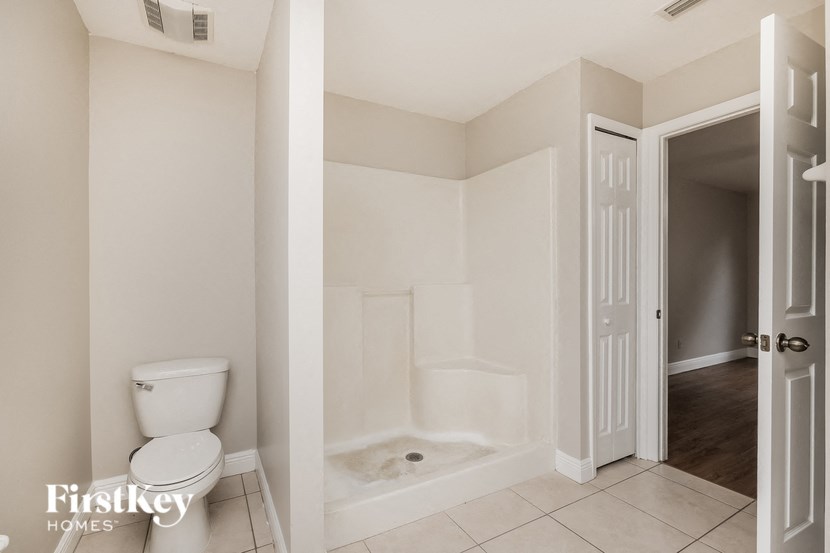 a bathroom with a toilet and a shower and a door