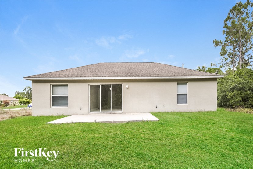 a small white house with a yard and grass