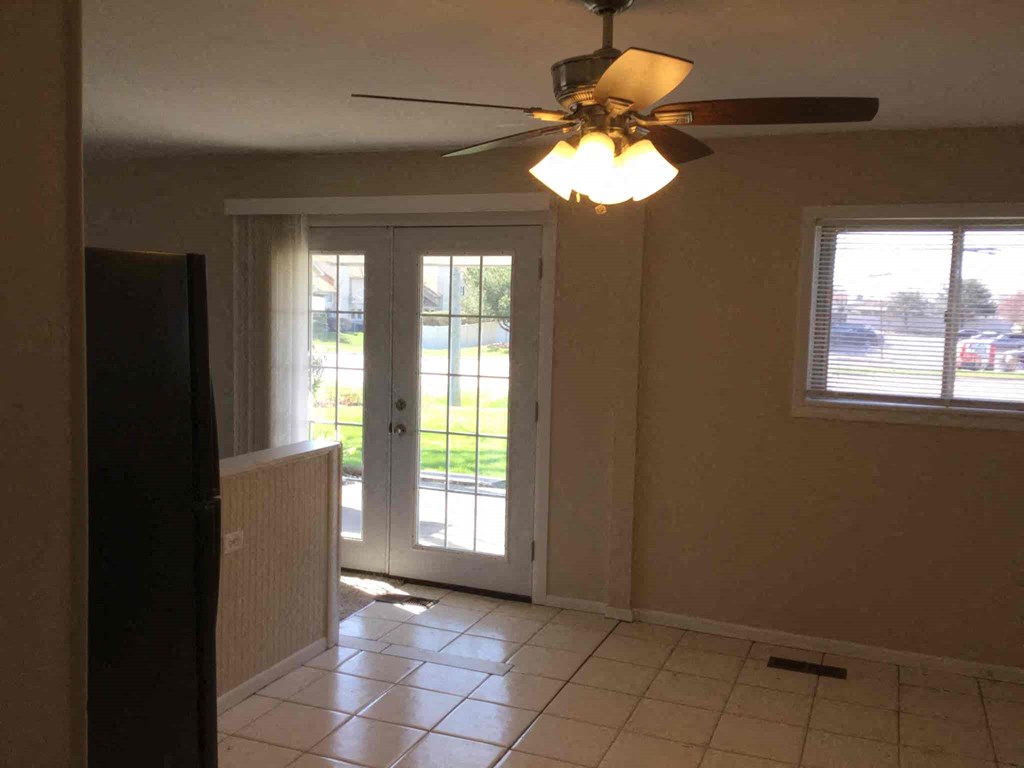 A room with a ceiling fan and a window.