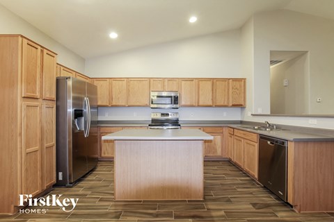 A kitchen with wooden cabinets and a refrigerator.