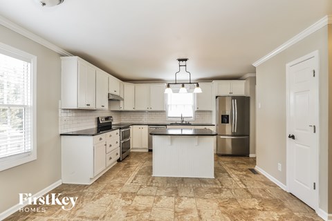 A kitchen with white cabinets and a tiled backsplash.