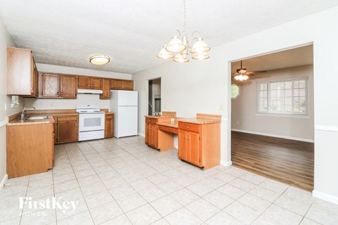A kitchen with wooden cabinets and a white refrigerator.