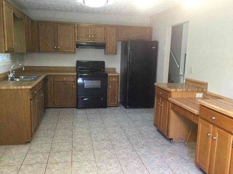A kitchen with black appliances and wooden cabinets.