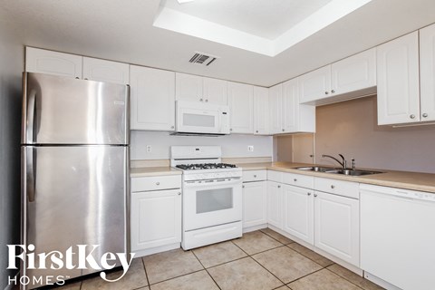 A kitchen with white cabinets and appliances.