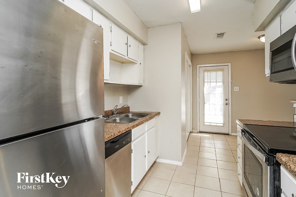 a kitchen with stainless steel appliances and white cabinets
