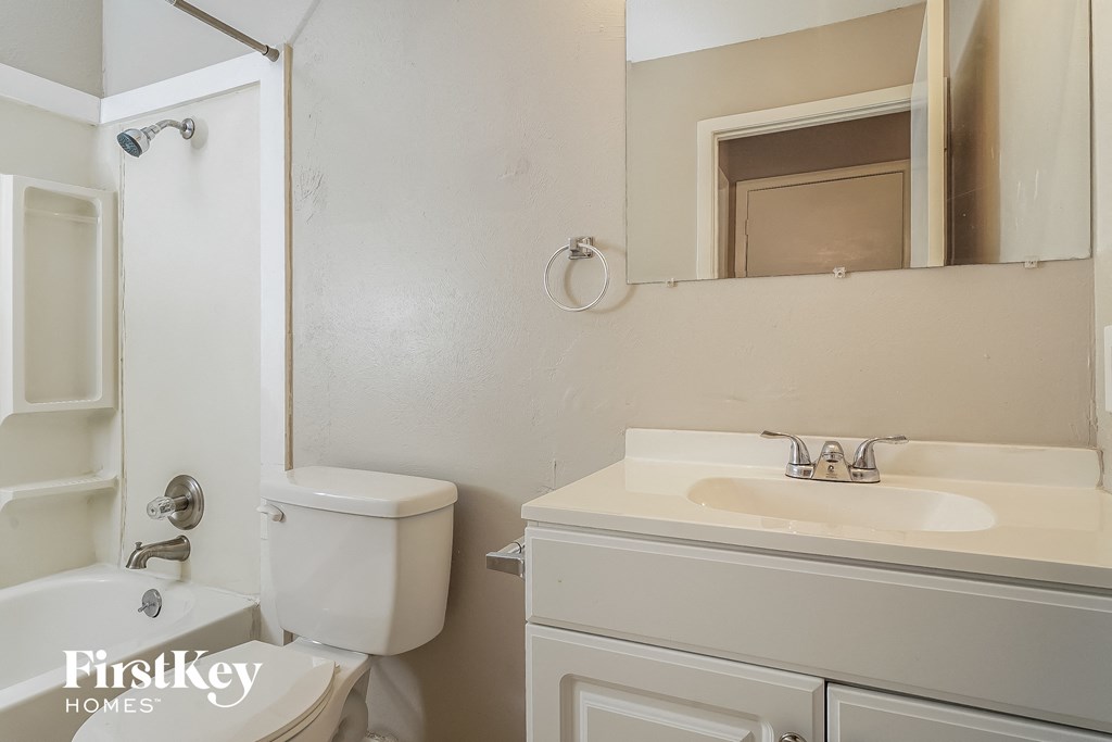 a bathroom with a sink toilet and a mirror
