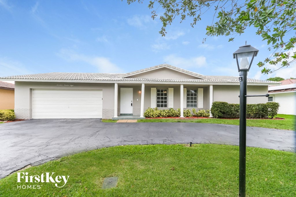 A house with a garage and a lamp post in front.