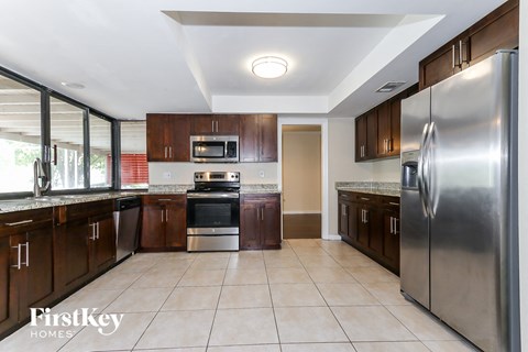 A kitchen with a refrigerator on the right side.