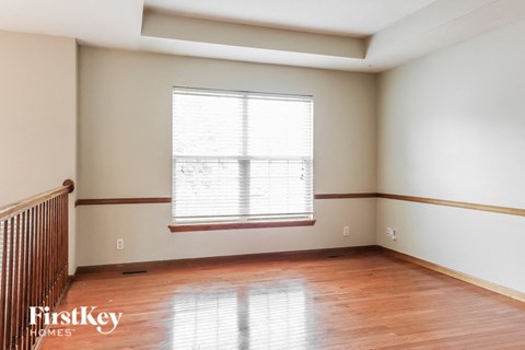 an empty room with wood floors and a window