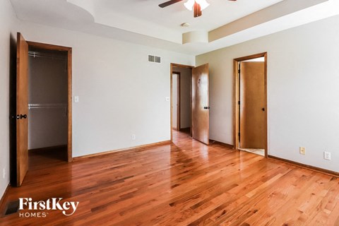 a living room with a hard wood floor and three doors