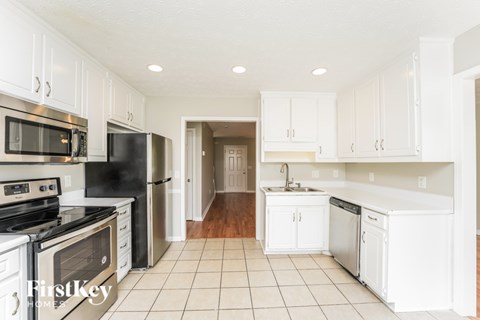 A kitchen with white cabinets and appliances.