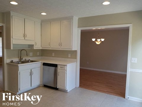 A kitchen with white cabinets and a sink.
