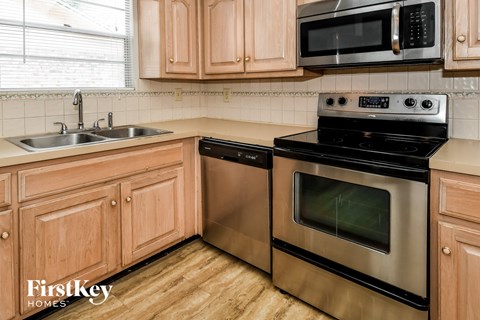 a kitchen with wooden cabinets and stainless steel appliances
