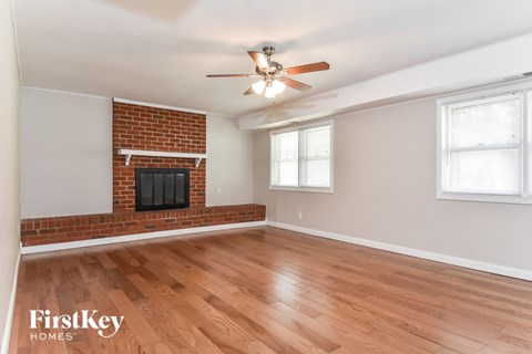 A room with a fireplace and a ceiling fan.