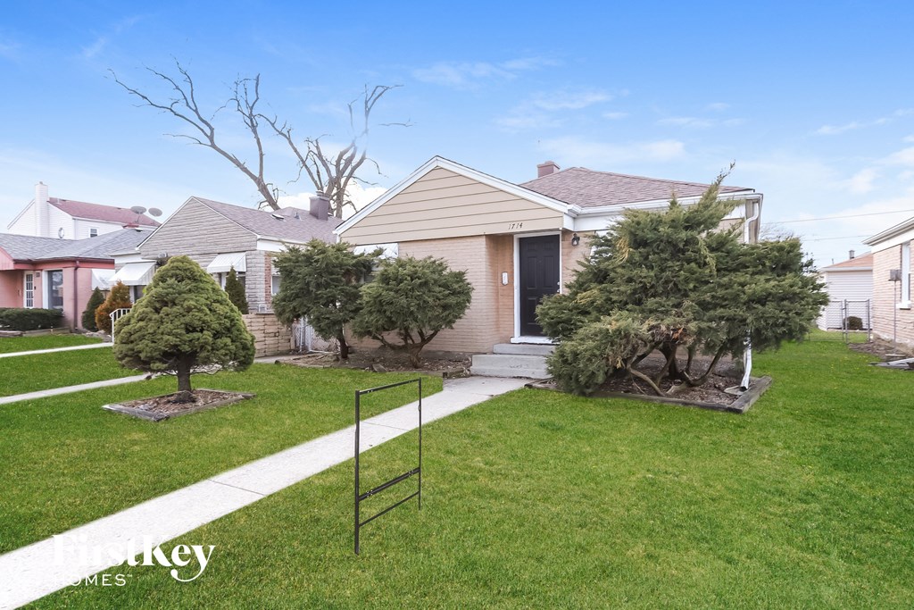 a home with a lawn and trees in front of it