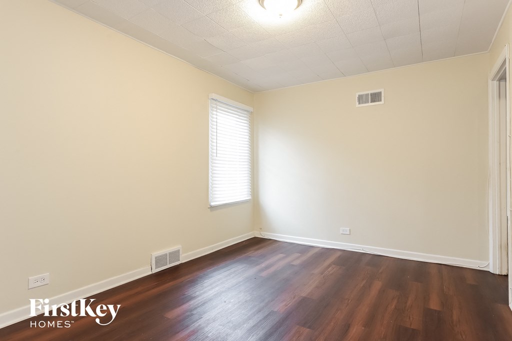 the interior of an empty room with wooden floors and white walls