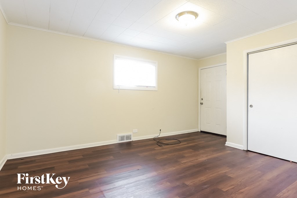 the living room of a house with wooden floors and a white door