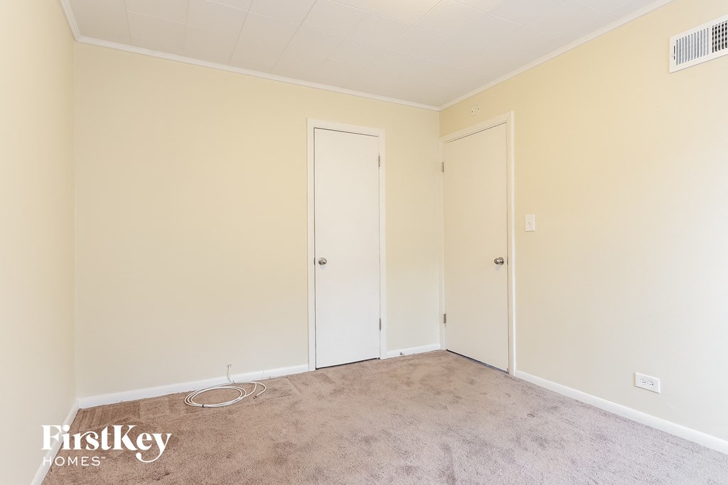 a bedroom with two doors and a carpeted floor