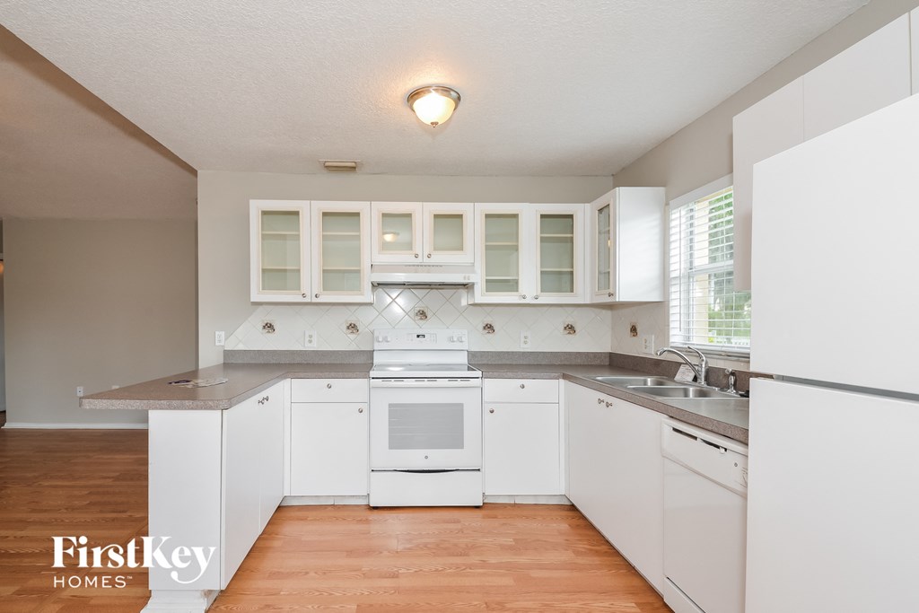 A kitchen with white appliances and cabinets.