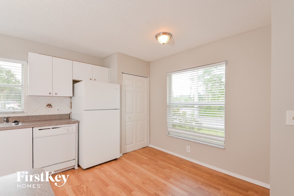 A kitchen with white appliances and cabinets.