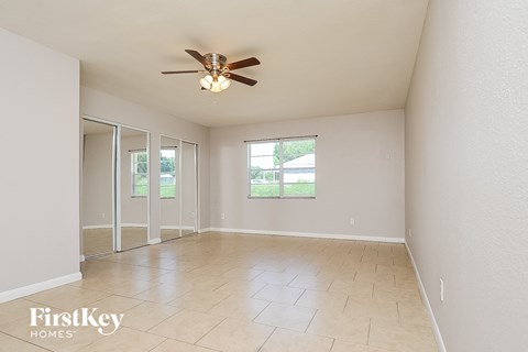 a living room with a ceiling fan and a tiled floor