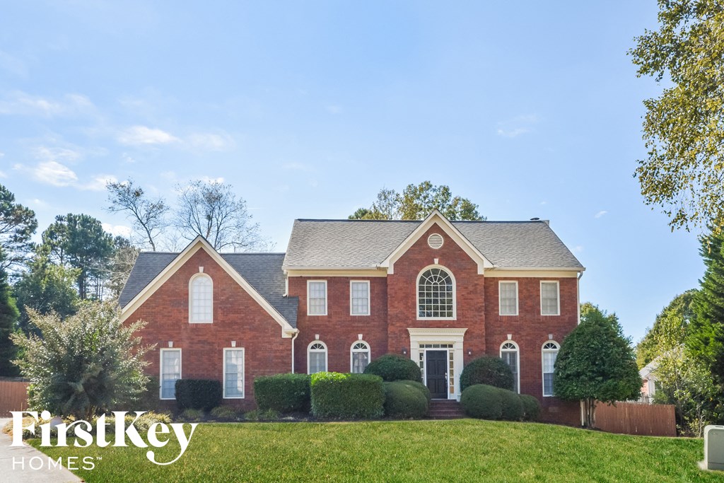 A red brick house with a white door and windows.