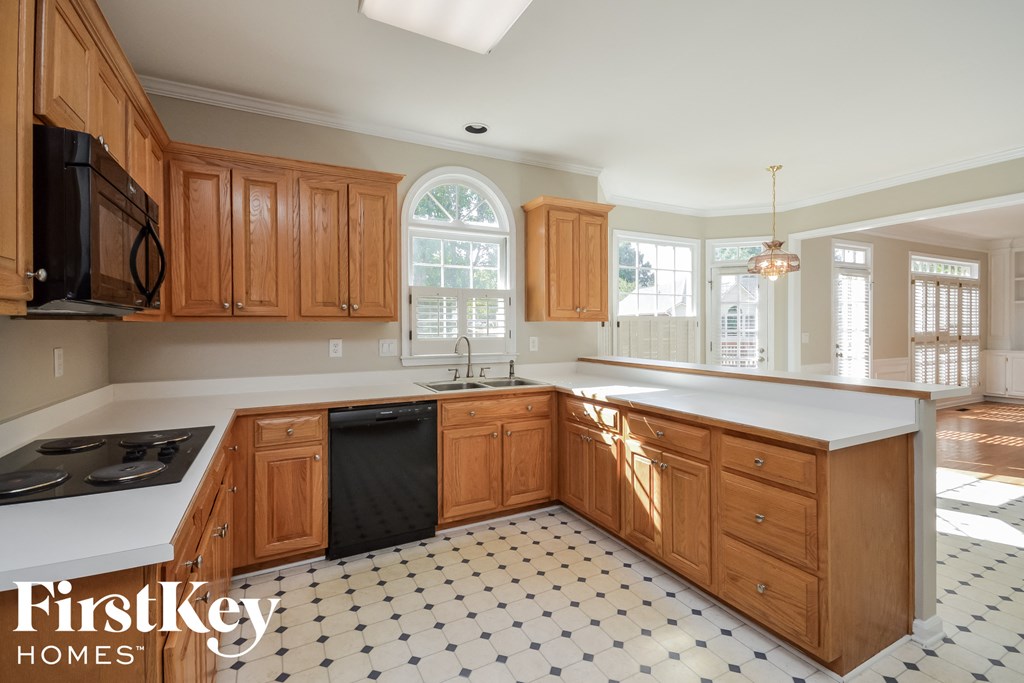 A kitchen with wooden cabinets and a black and white checkered floor.