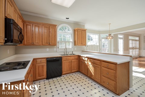 A kitchen with wooden cabinets and a black and white checkered floor.