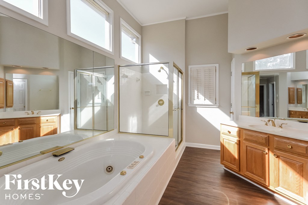 A large, modern bathroom with a walk-in shower and double sinks.