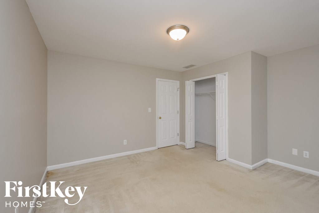 A room with a white door and a light on the ceiling.