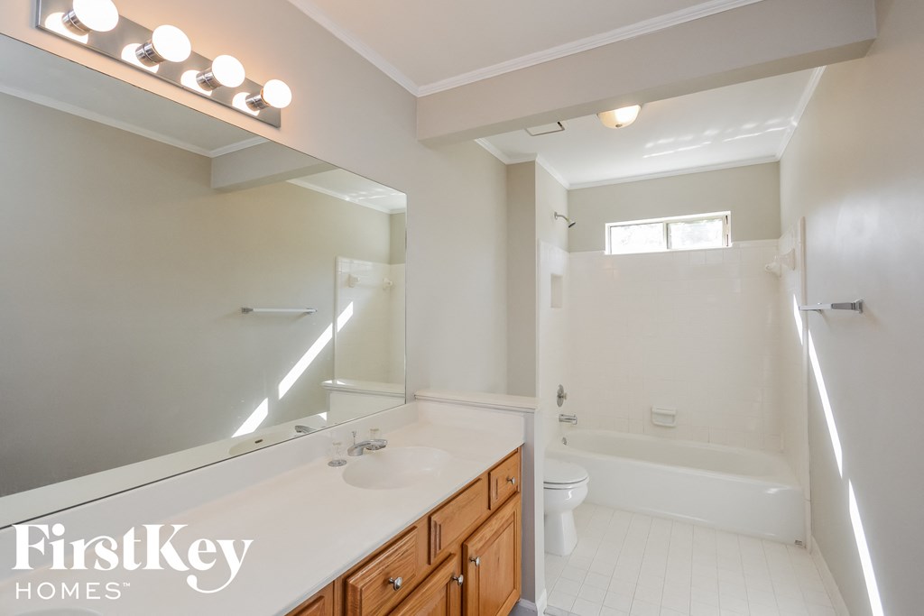 A bathroom with a white countertop and a large mirror.