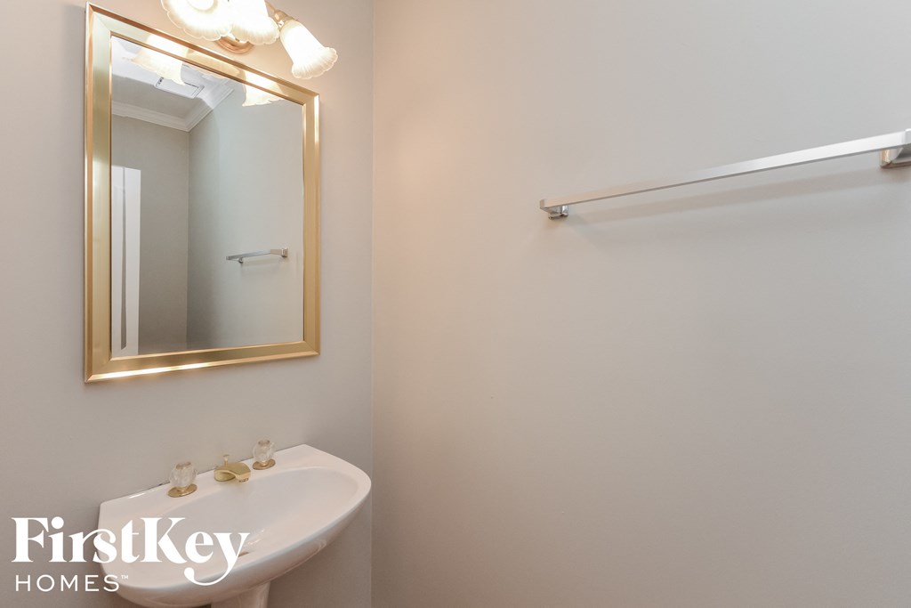A white sink in a bathroom with a mirror above it.