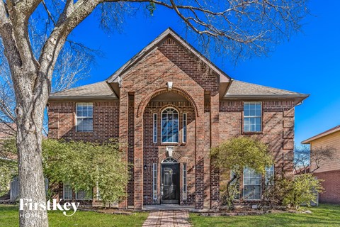 home for sale with a large brick facade and a tree