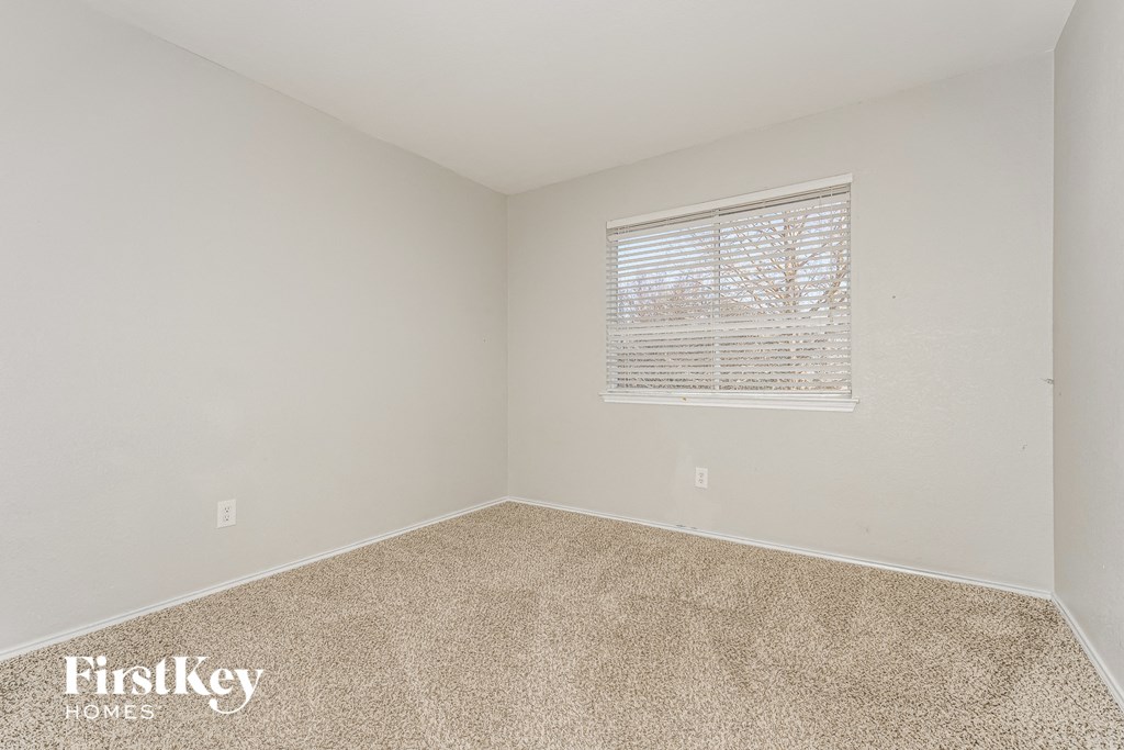 a bedroom with carpet and a window