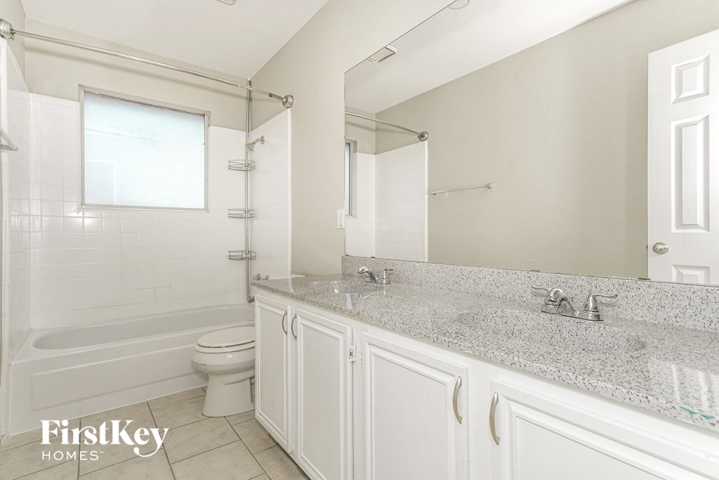 a bathroom with white cabinets and a sink and a toilet
