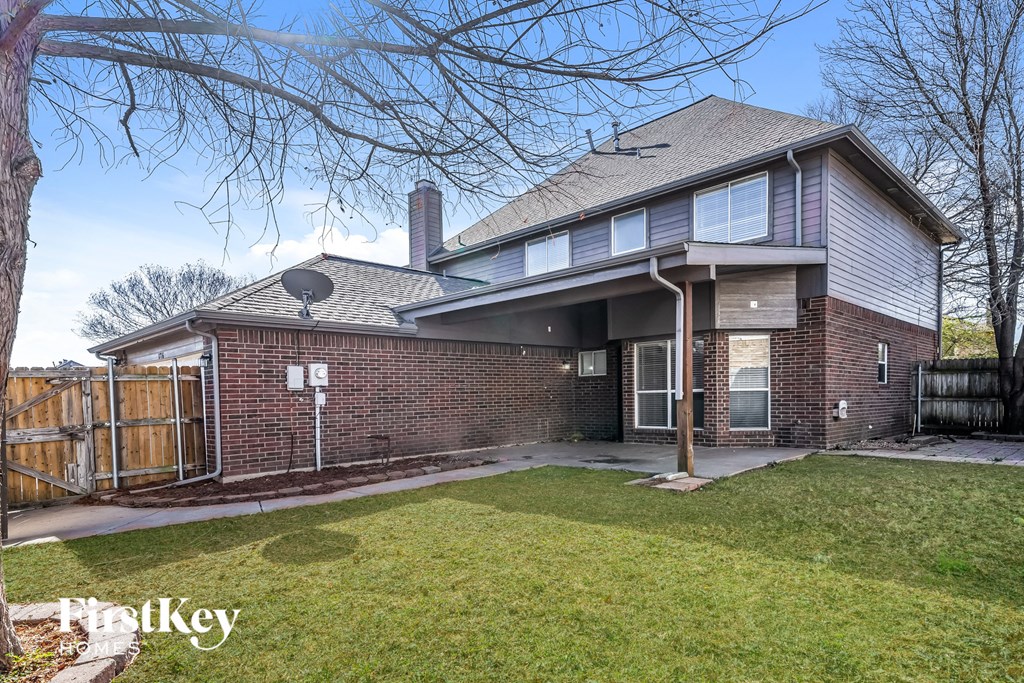 a brick house with a yard and a wooden fence