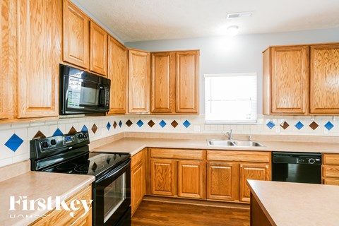 A kitchen with wooden cabinets and a black stove top oven.