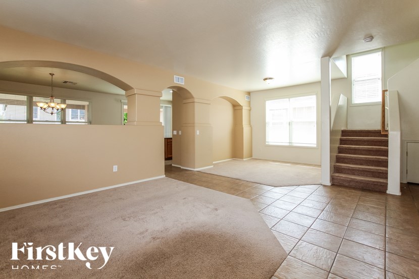A spacious room with a staircase and a rug on the floor.