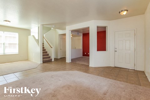 A spacious living room with a staircase leading to the upper floor.
