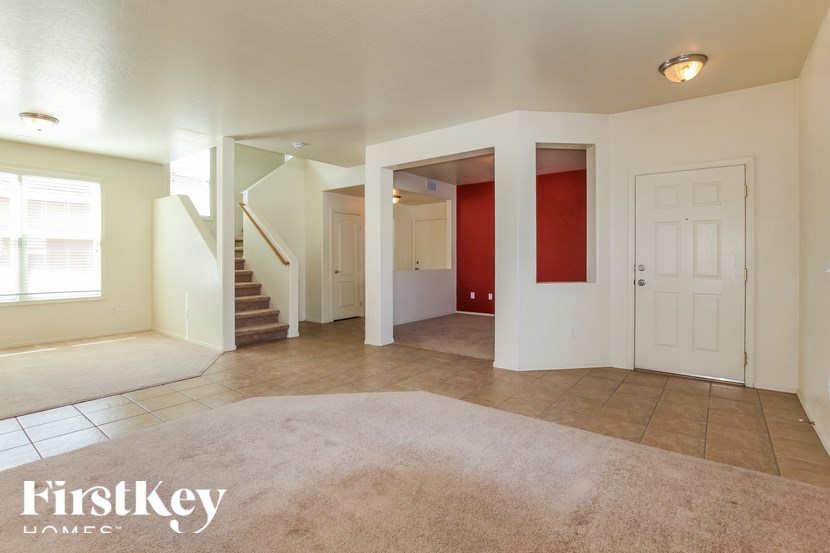 A spacious living room with a staircase leading to the upper floor.