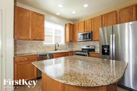 A kitchen with wooden cabinets and granite countertops.