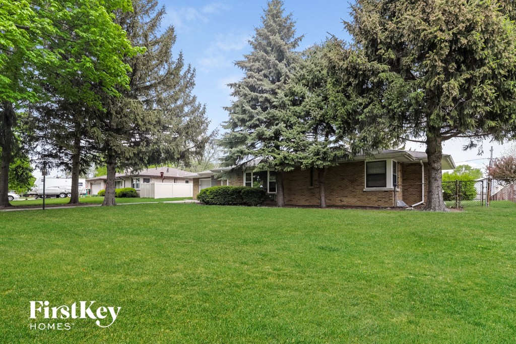 A house with a lawn and trees in the background with the words "FirstKey Homes" on the bottom.