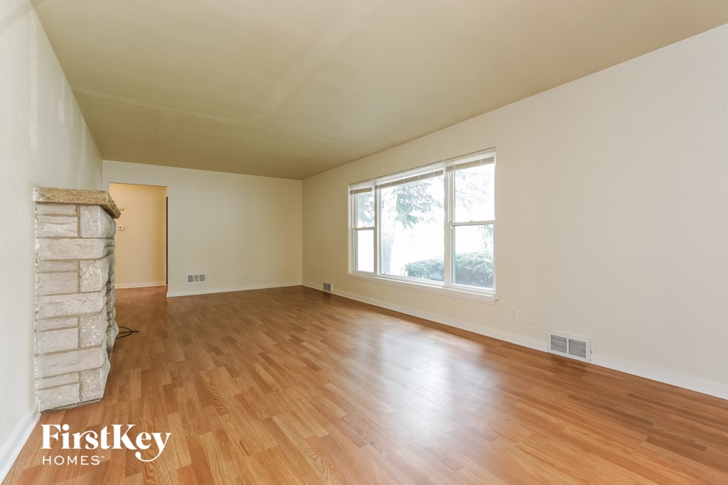A room with wooden floors and a window letting in light.