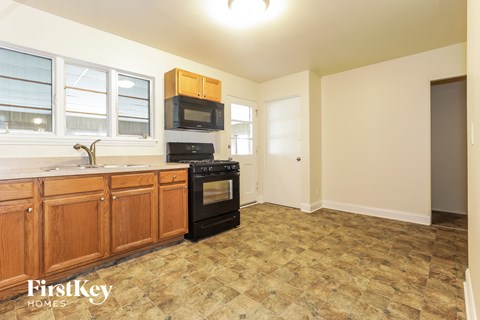 A kitchen with wooden cabinets and a black oven.